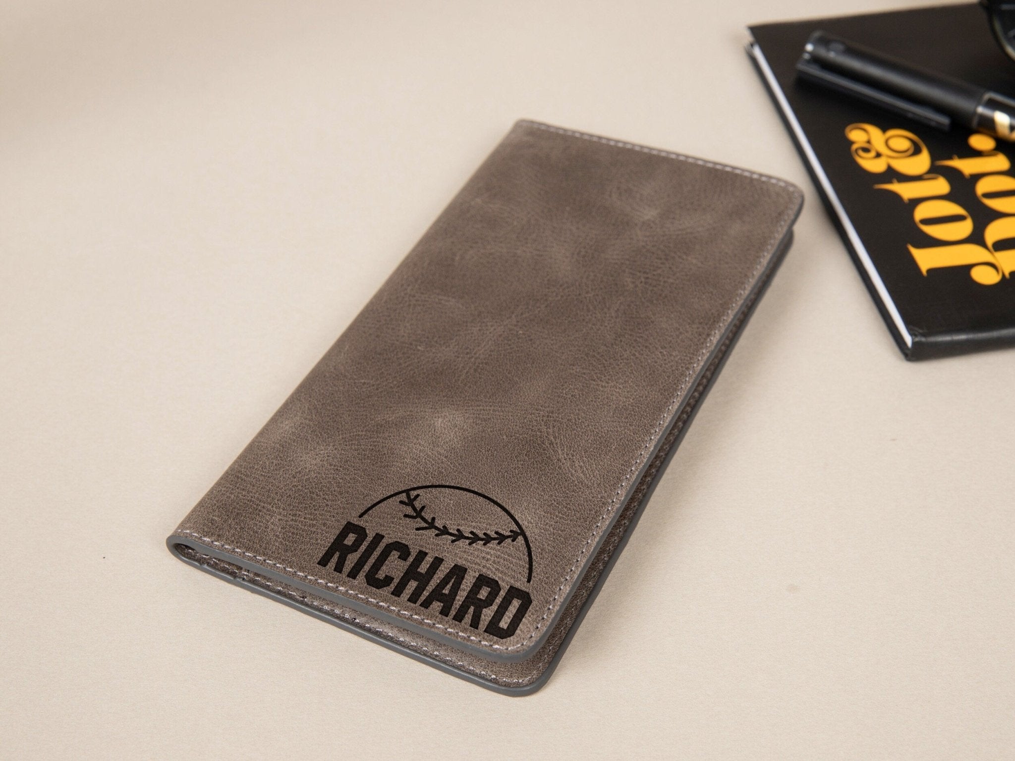 Baseball Long Wallet • Personalized Genuine Leather Wallet - The Lush Gifts - Baseball Long Wallet • Personalized Genuine Leather Wallet - The Lush Gifts - The Lush Gifts - Card Holder - Black - a notebook and pen sitting on a table - Customized Leather Gift - Personalized Leather Gift