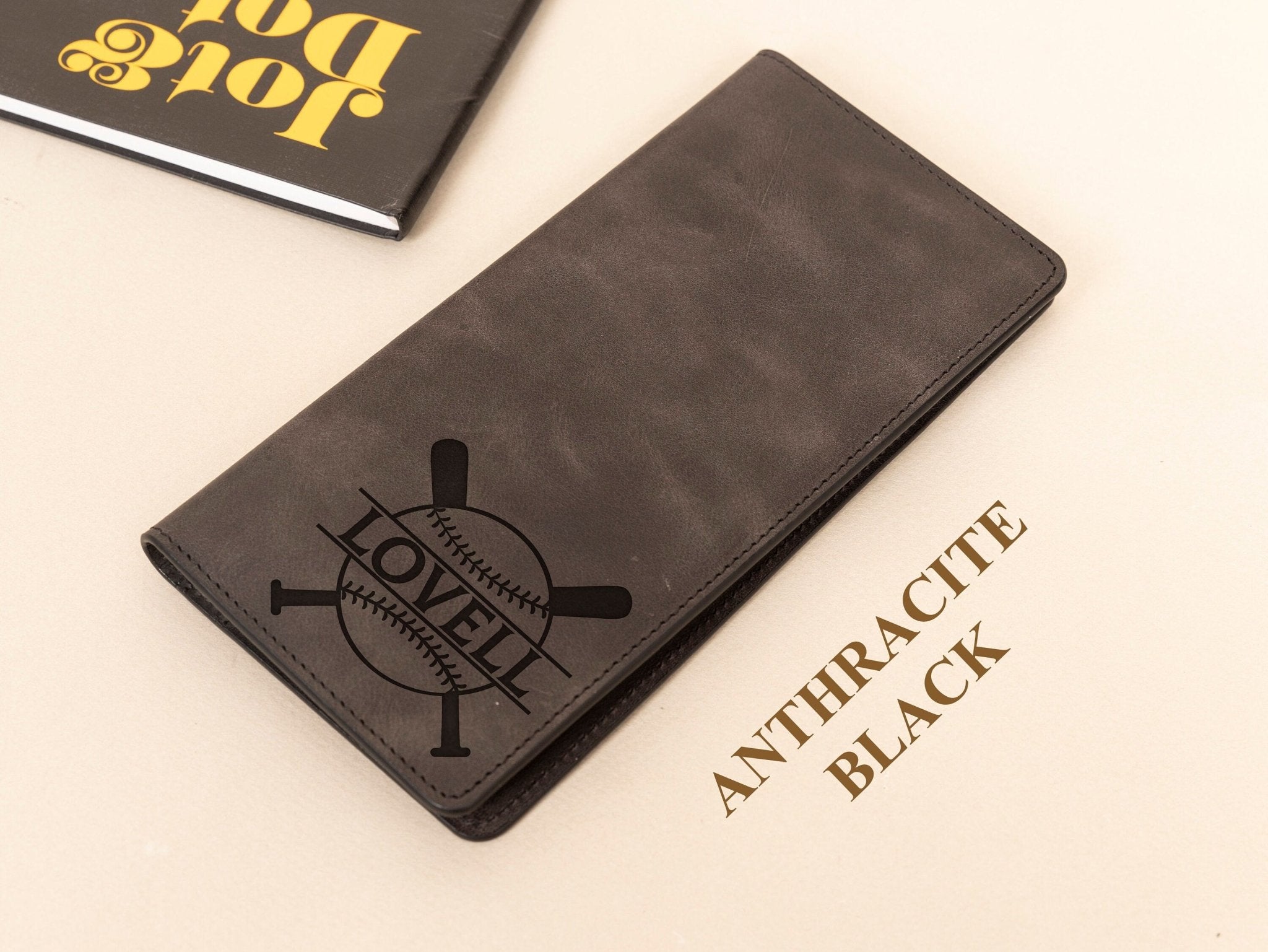 Baseball Long Wallet • Personalized Genuine Leather Wallet - The Lush Gifts - Baseball Long Wallet • Personalized Genuine Leather Wallet - The Lush Gifts - The Lush Gifts - Card Holder - Black - a wallet sitting on top of a table next to a book - Customized Leather Gift - Personalized Leather Gift