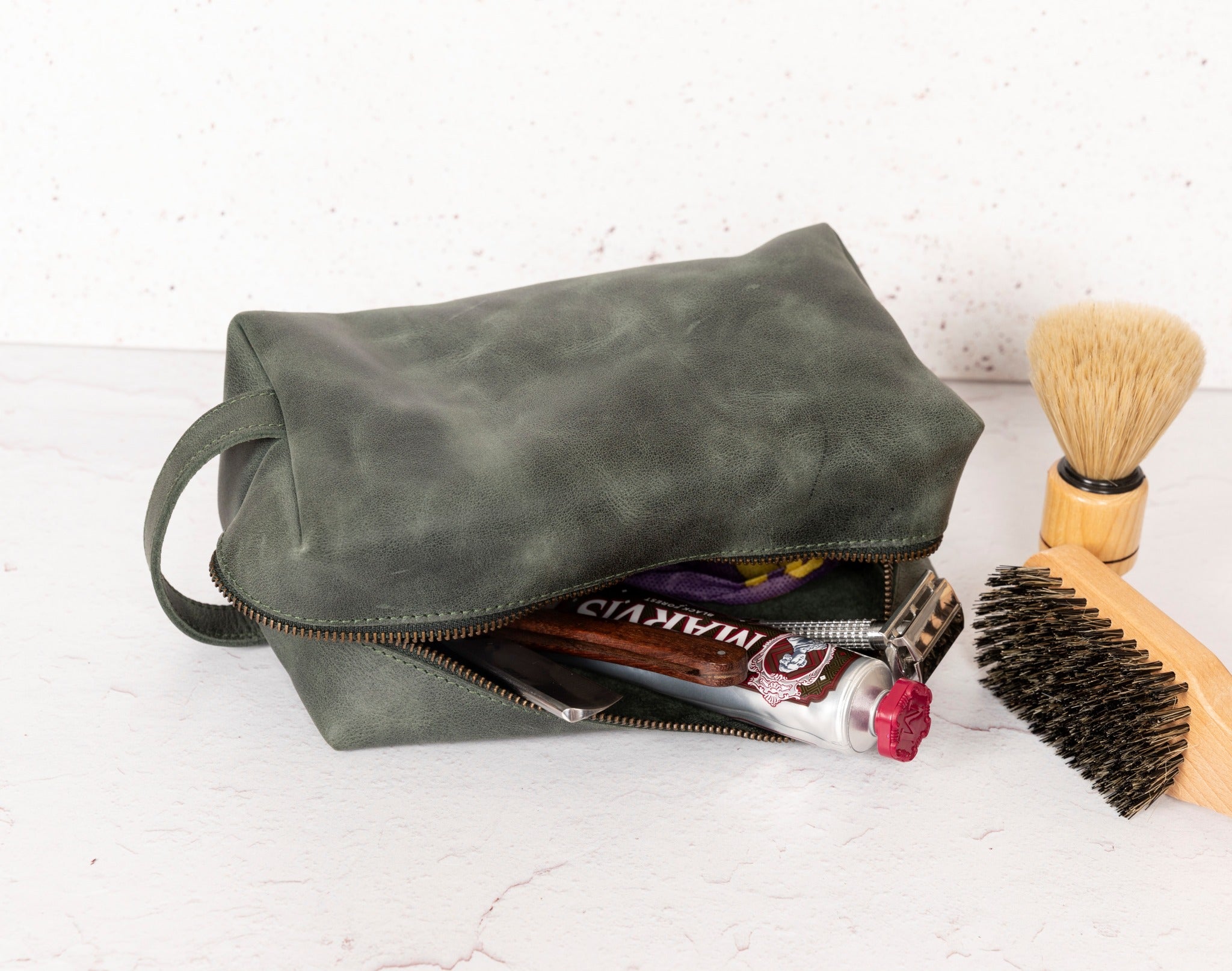 a bag with a brush, shaving brush, and other items