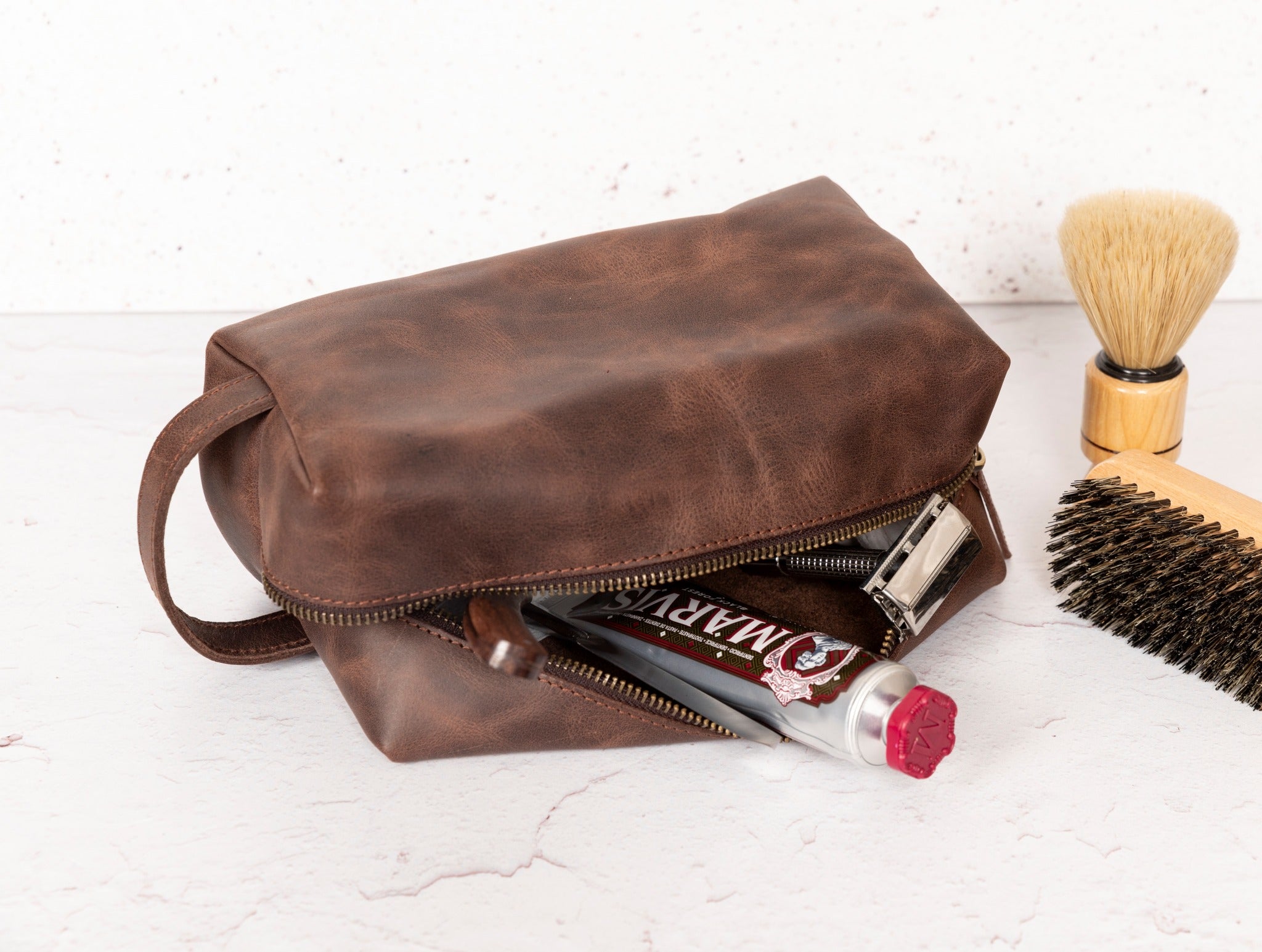 Gym Themed Dopp Kit • Leather Toiletry Bag • Custom Gift - The Lush Gifts - Gym Themed Dopp Kit • Leather Toiletry Bag • Custom Gift - The Lush Gifts - The Lush Gifts - a brown bag sitting next to a brush and a comb - Customized Leather Gift - Personalized Leather Gift